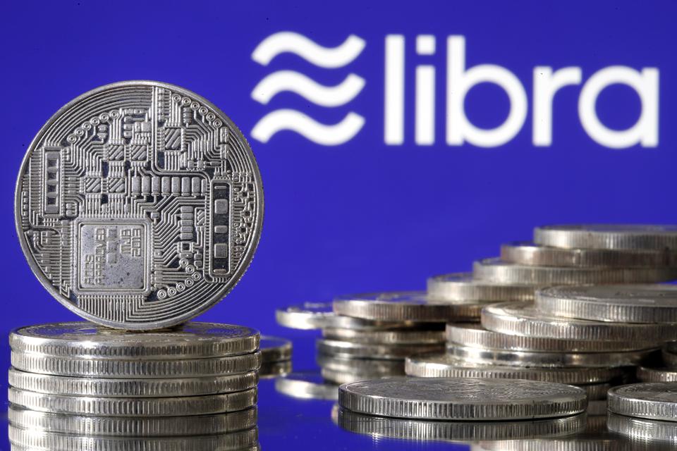 PARIS, FRANCE - JUNE 24: In this photo illustration, a visual representation of a digital... [+] cryptocurrency coin sits on display in front of a Libra logo on June 24, 2019 in Paris, France. Since the announcement of its creation a few days ago, the virtual currency of Facebook Libra fascinates as much as it worries. Thus, a few days after the announcement of the arrival of the social network in the sector, the Bank for International Settlements (BIS) considers that the incursion of major technologies into financial activity presents "new and complex compromises between financial stability , competition and data protection ". (Photo by Chesnot/Getty Images)