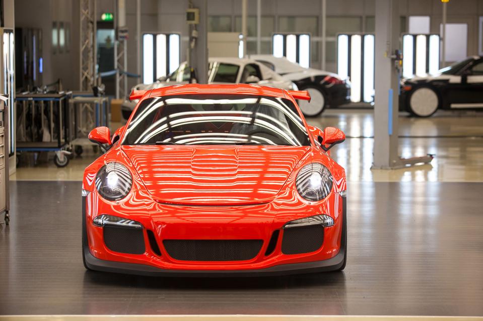 A red Porsche 911 GT3 RS automobile stands illuminated under strip lights ahead of shipping from the Porsche AG factory in Stuttgart, Germany. Photographer: Krisztian Bocsi/Bloomberg