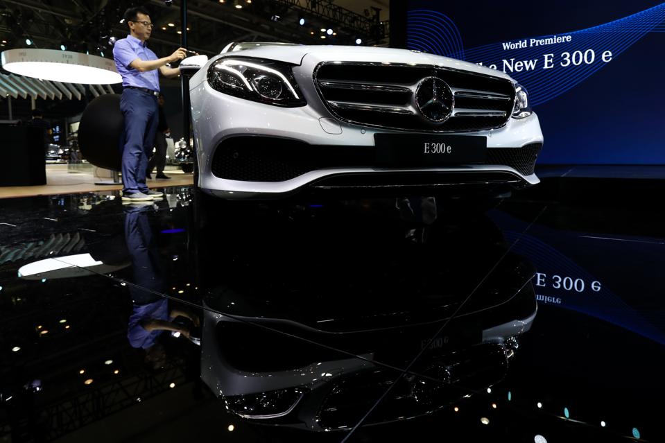 An attendee takes a photograph of a Mercedes-Benz AG E300e during the press day of the 2018 Busan International Motor Show in Busan, South Korea Photographer: SeongJoon Cho/Bloomberg