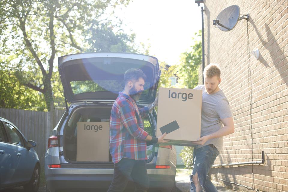 Homebuilder Shares Tips For First Time Home Buyers Male gay couple unloading moving boxes from car