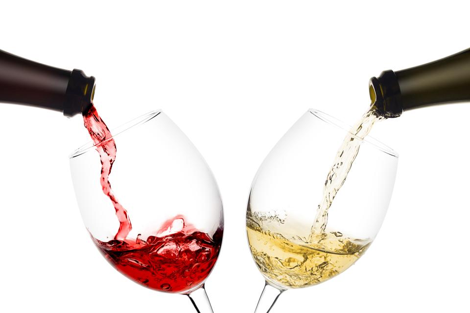red and white wine poured from a bottle into wine glass on white background, isolated