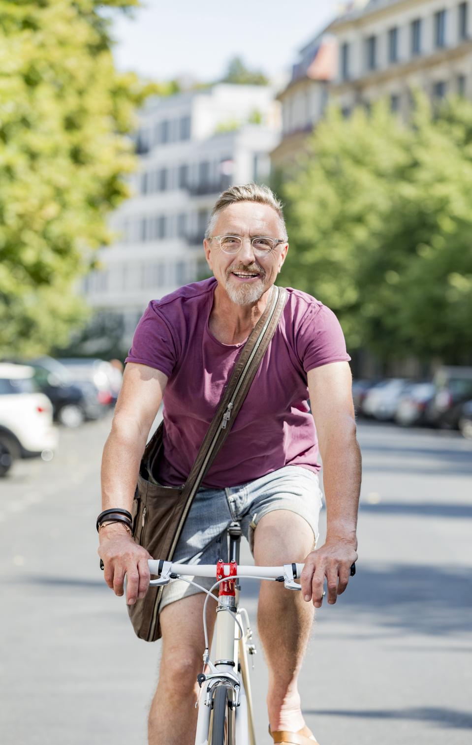 Un homme âgé actif au début de la soixantaine aime la vie citadine en été.