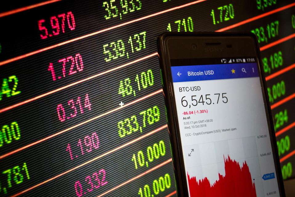 A smartphone displays the Bitcoin USD market value on the