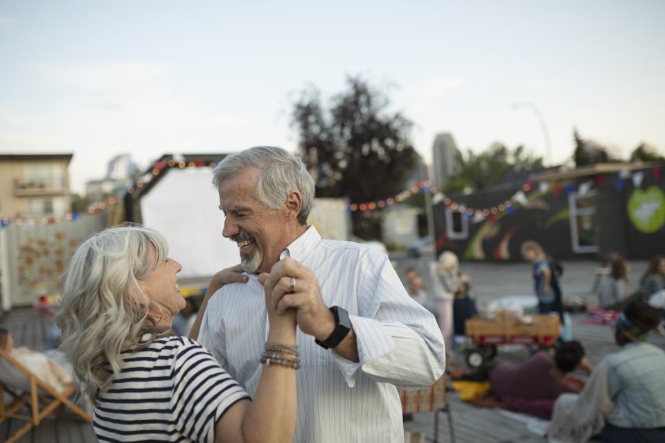 Playful senior couple dancing at movie in the park