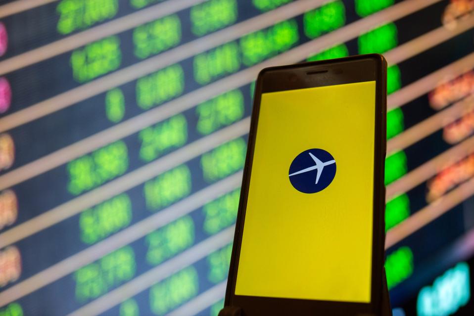 The Expedia app is seen on a smartphone...