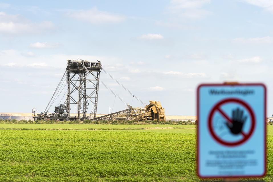 Germany, Garzweiler surface mine, warning sign and giant bucket-wheel excavator