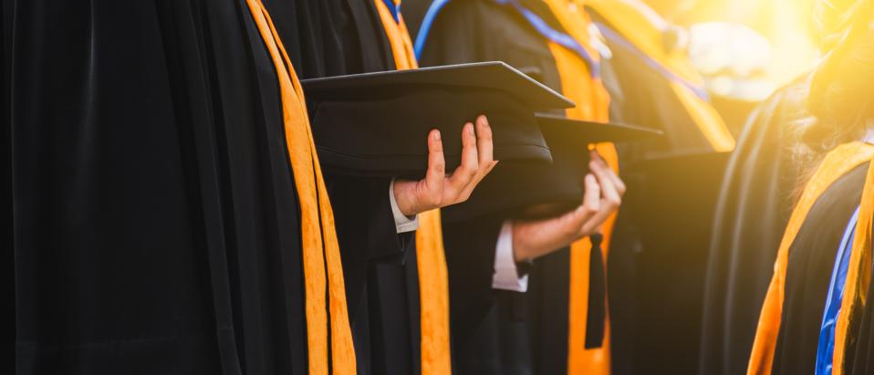 Close up of Graduate holding a hat.