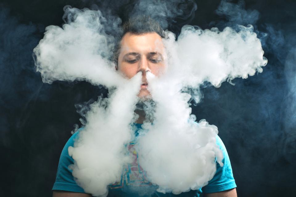 Vaping man and a cloud of vapor