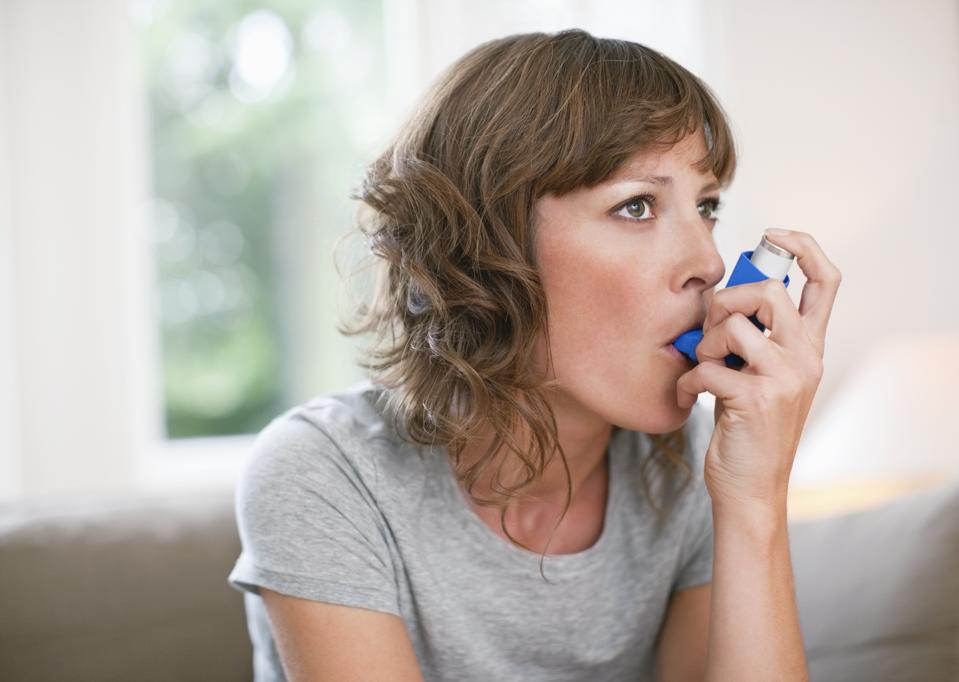 Woman using asthma inhaler