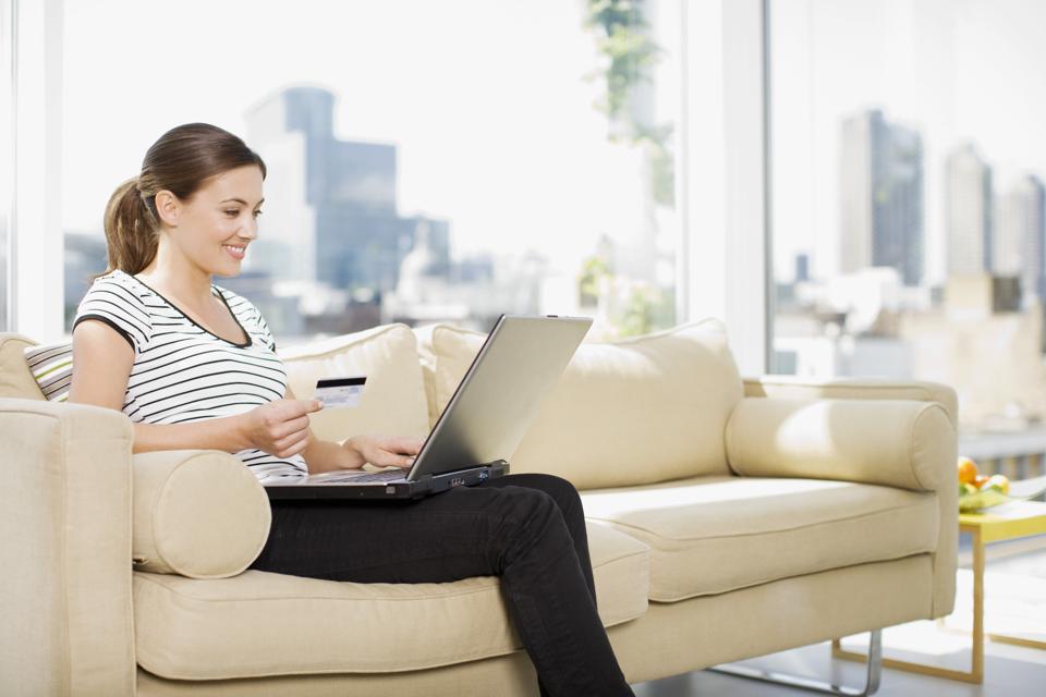 Woman using credit card to purchase merchandise on internet