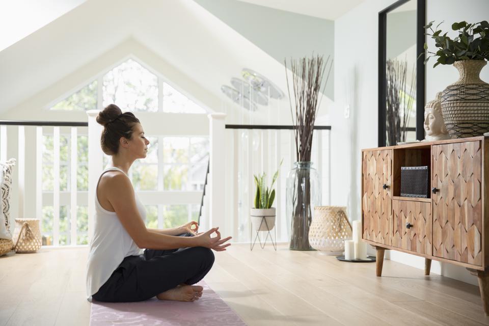 Peaceful woman meditating at home