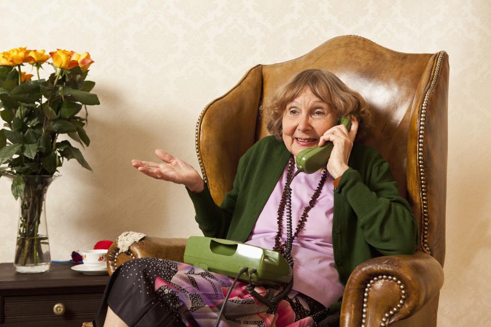 A senior woman talking on the phone in her living room
