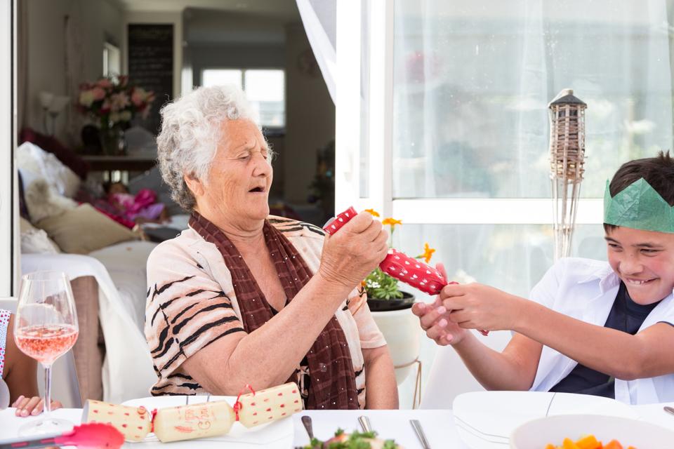 Grand-mère et petit-fils tirent des biscuits de Noël à table