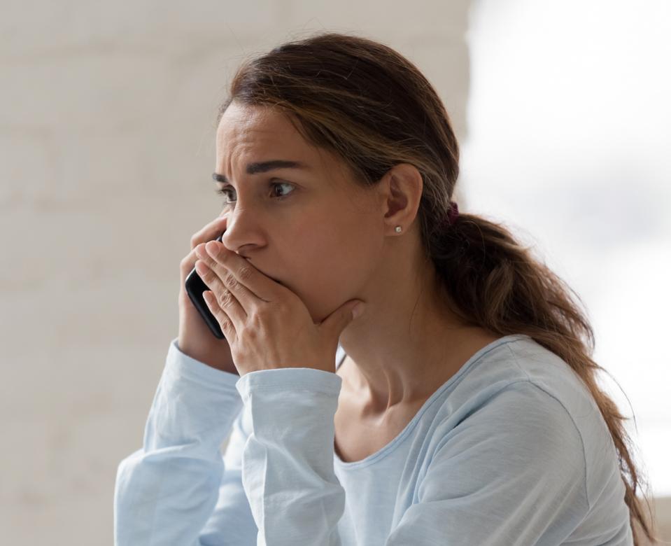 Scared shocked woman talking on phone, receiving bad news