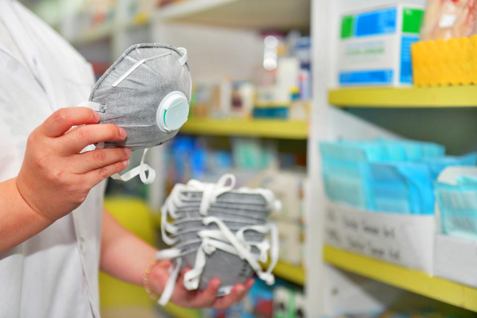 Pharmacist hand holding N95 mask in pharmacy