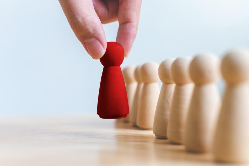 Human resource, Talent management, Recruitment employee, Successful business team leader concept. Hand chooses a wooden people standing out from the crowd.