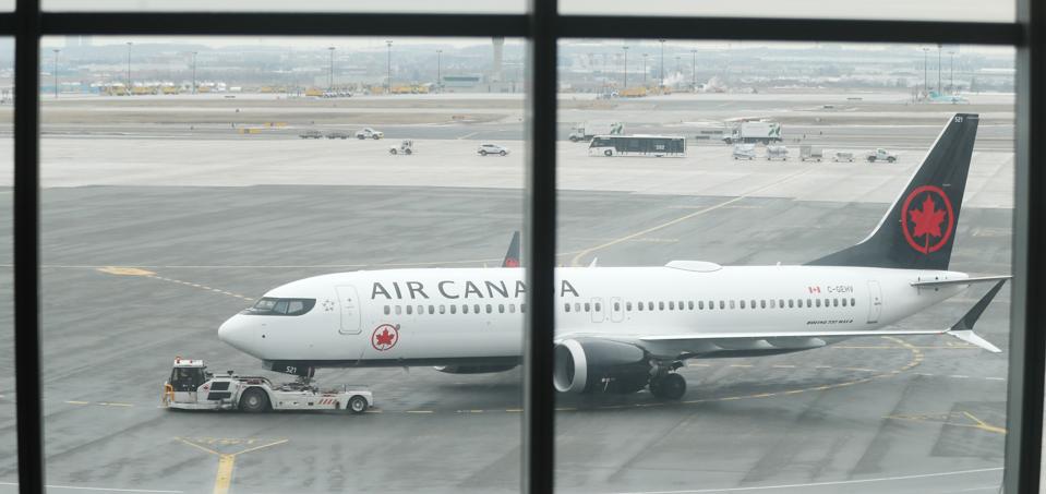 Air Canada Registration number C-GEHV which had just come in as Flight AC 758, from San Francisco, a 737 Max 8, is rolled out of the gate after being grounded,