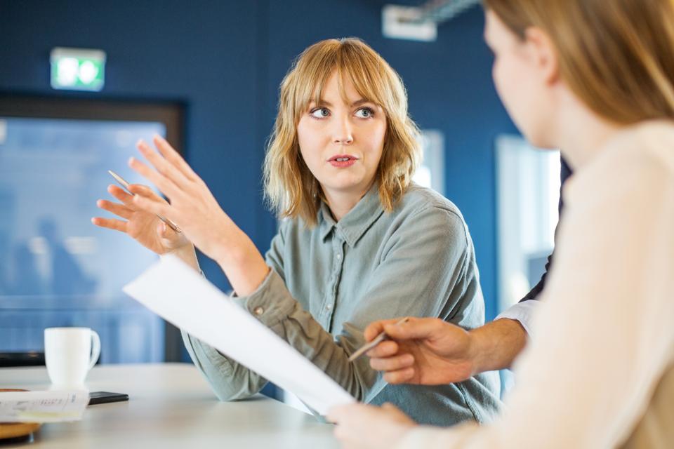 Businesswoman sharing ideas with colleague in meeting