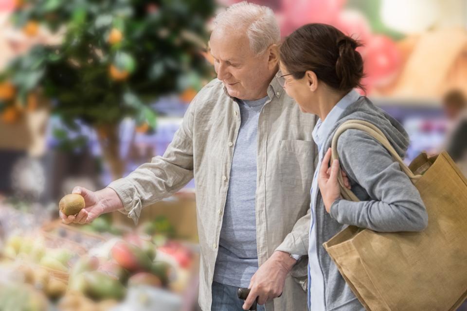 Senior man with home caregiver shopping