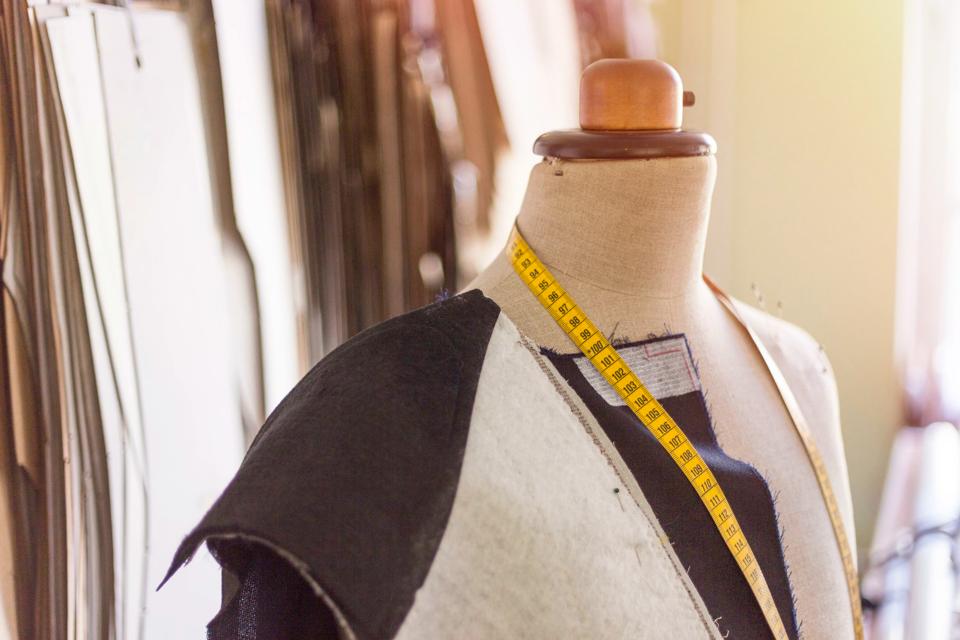 Tailored suit jacket on a mannequin during construction at bespoke tailor's workshop.
