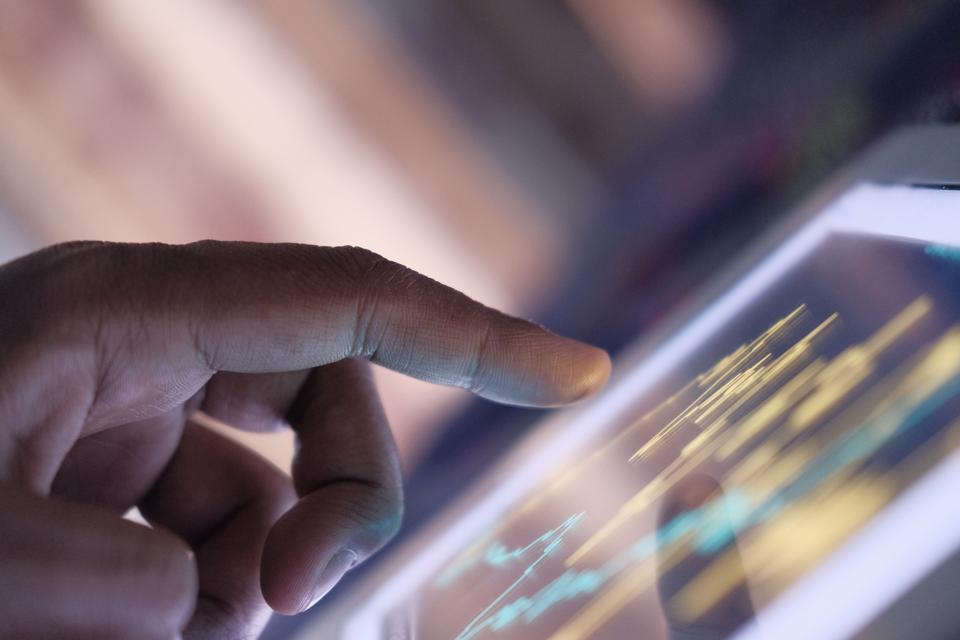 Business man analyzing stock market charts on digital tablet at home
