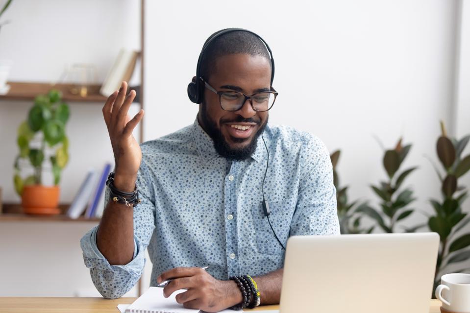 A smiling student learns a foreign language online