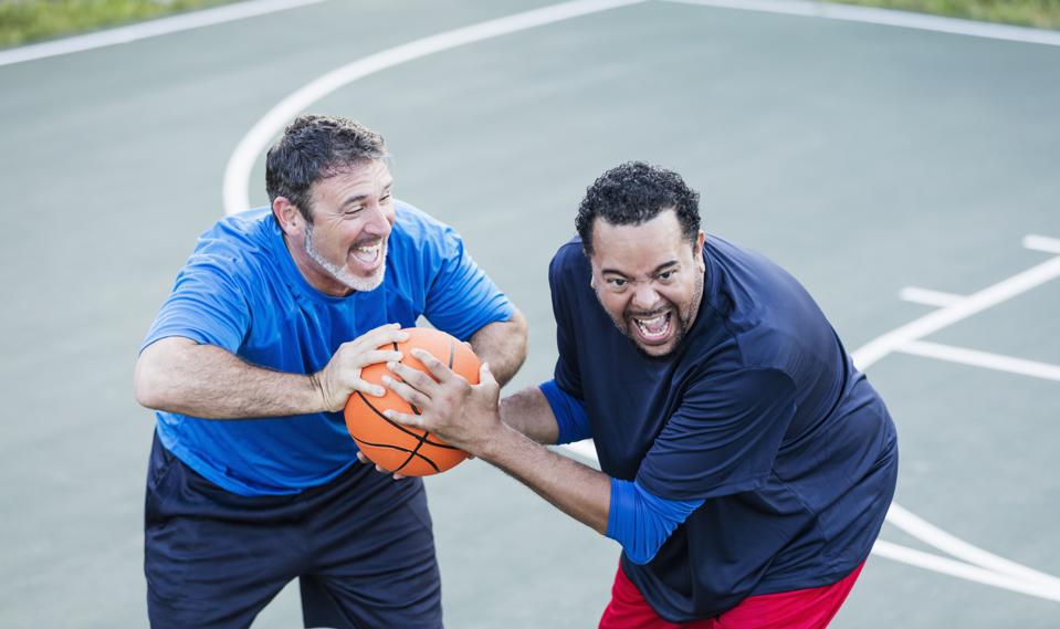 Mature men having fun playing basketball