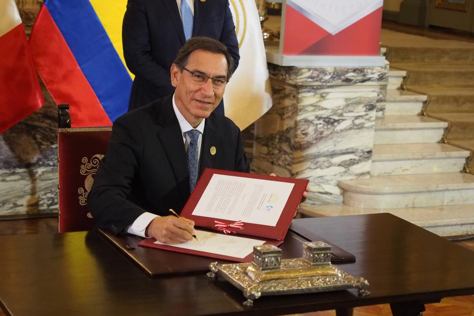 Martin Vizcarra, President of Peru, signing an agreement as...