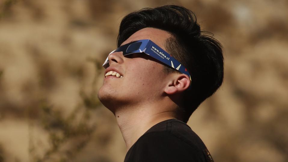 A young Chilean watches the sky with eclipse glasses prior to a total solar eclipse on July 2, 2019 in Paiguano, Chile. (Photo by Marcelo Hernandez/Getty Images)