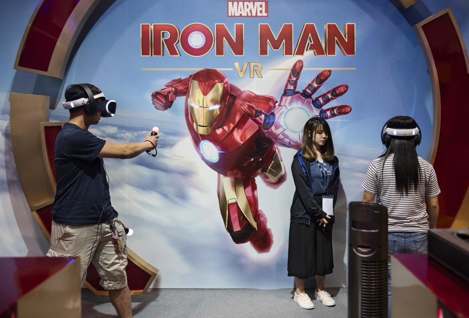 Visitors are seen playing a Marvel Iron man game with a...