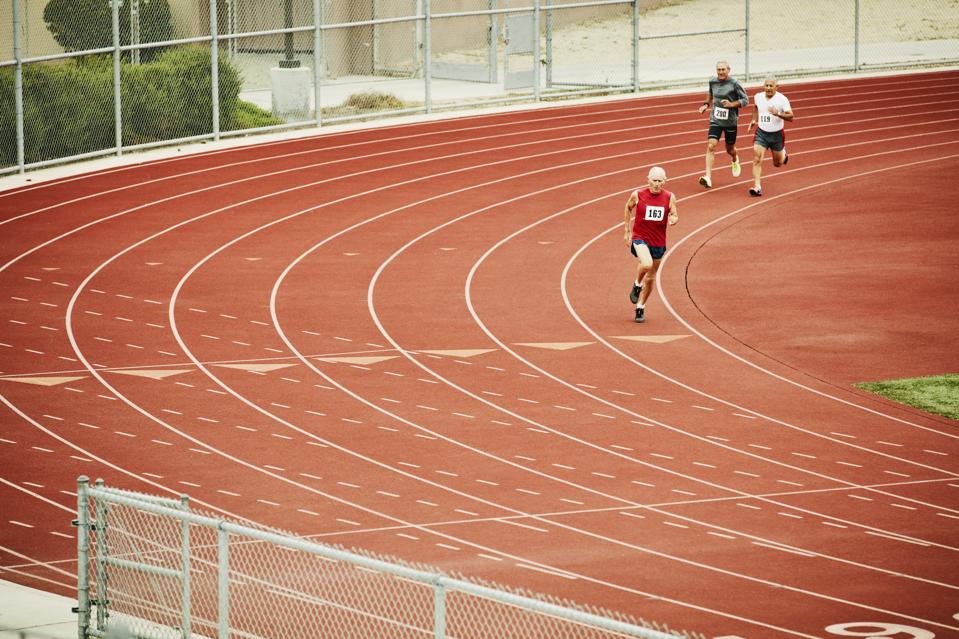 Senior male track athletes running distance race on track
