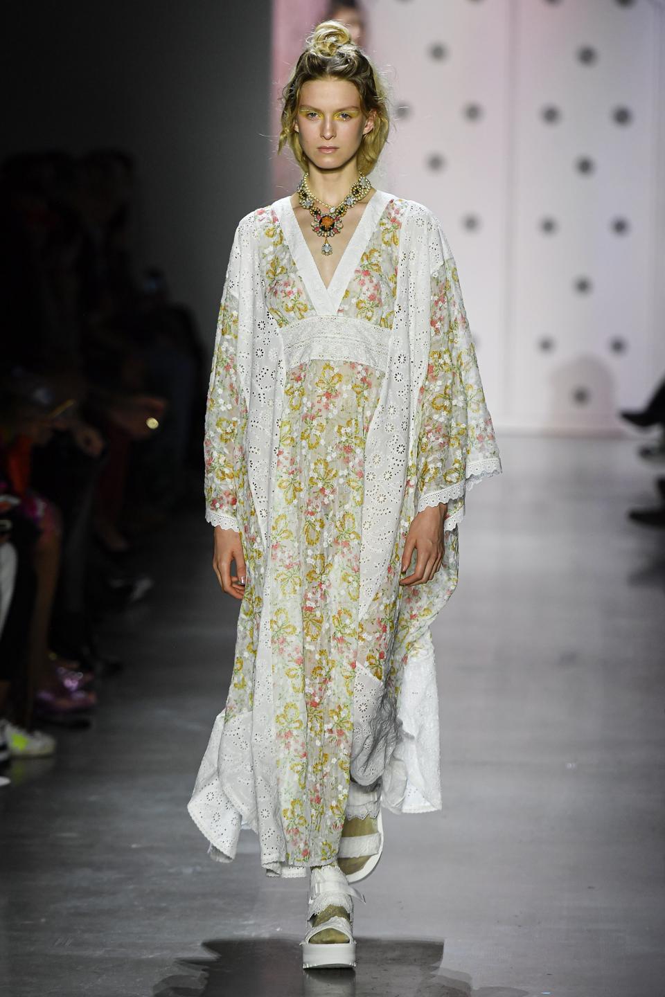 A model wearing Anna Sui's a look from the Spring 2020 Runway collection, a floral long dress with matching robe style jacket
