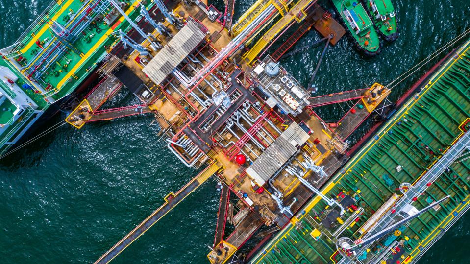 Aerial top view of two fuel tanker ship at the port, Oil terminal is industrial facility for storage of oil and gas petrochemical products ready for transport to further storage facilities.