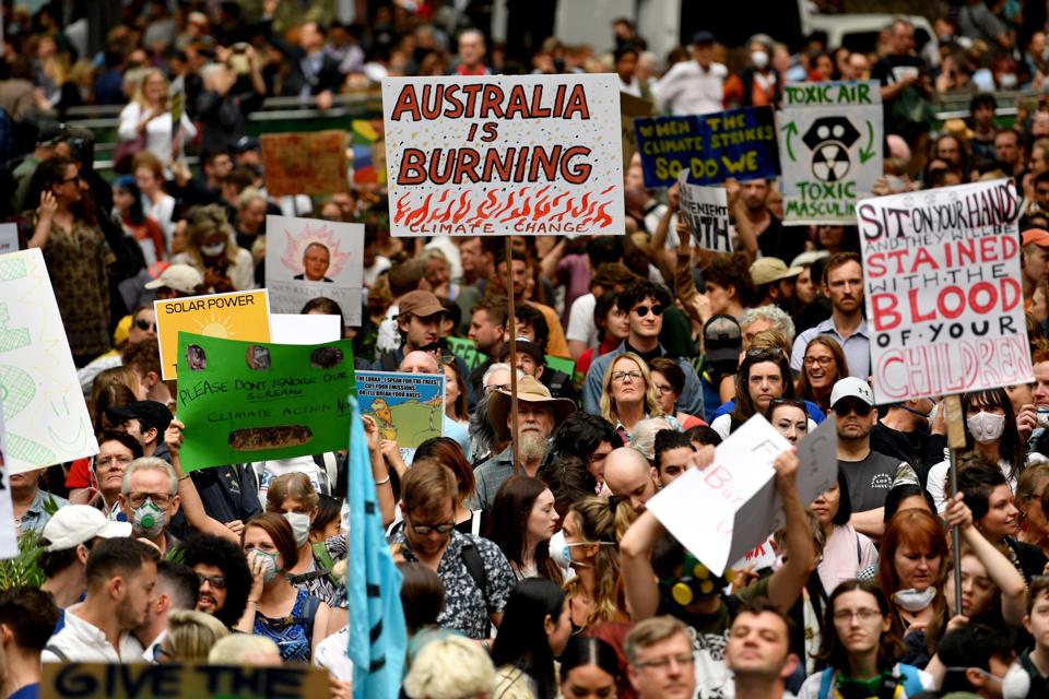 Demonstrators raise placards at a climate protest rally in Sydney on December 11.