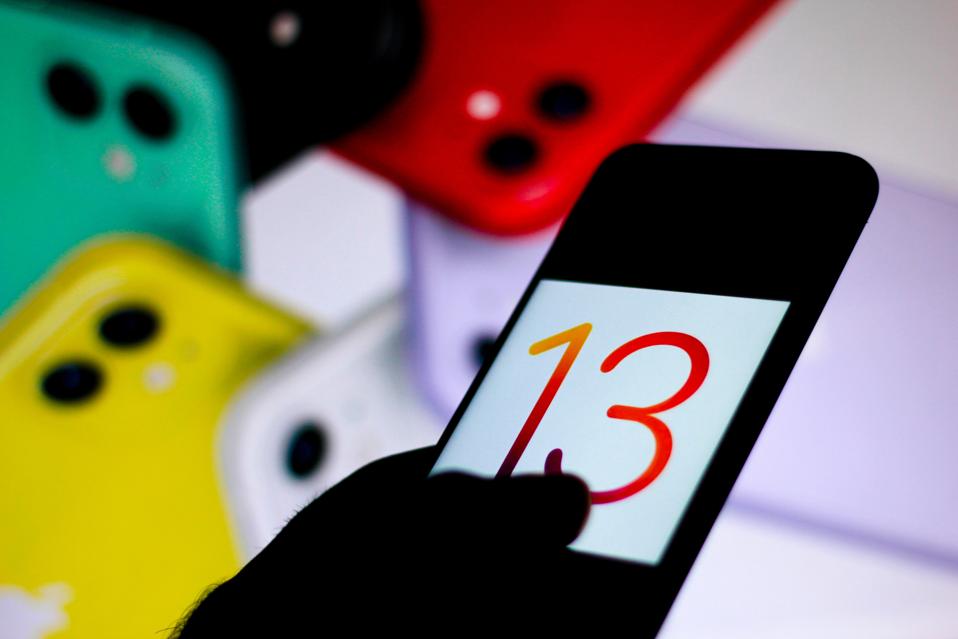 In this photo illustration the iOS 13 logo is seen displayed...