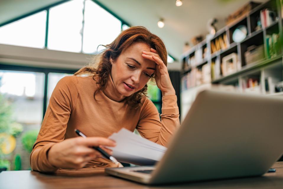 Portrait of a worried woman looking through finance.