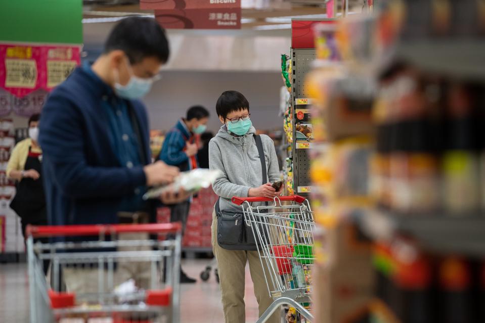Shoppers wearing surgical masks while shopping in a...
