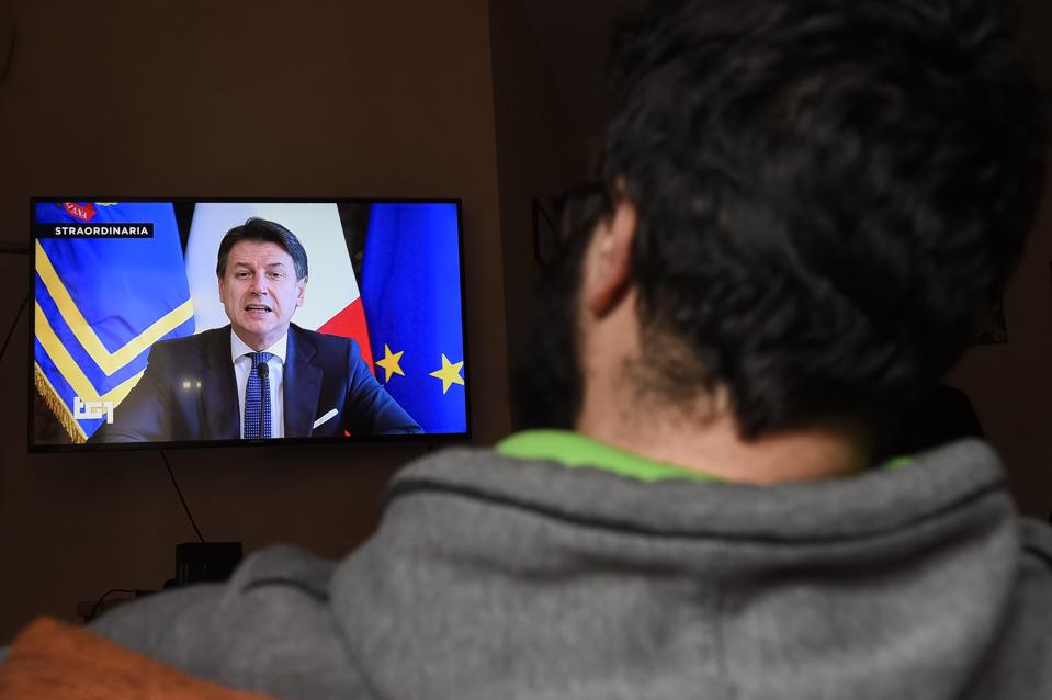 A man watches Italian Prime Minister Giuseppe Conte on TV...