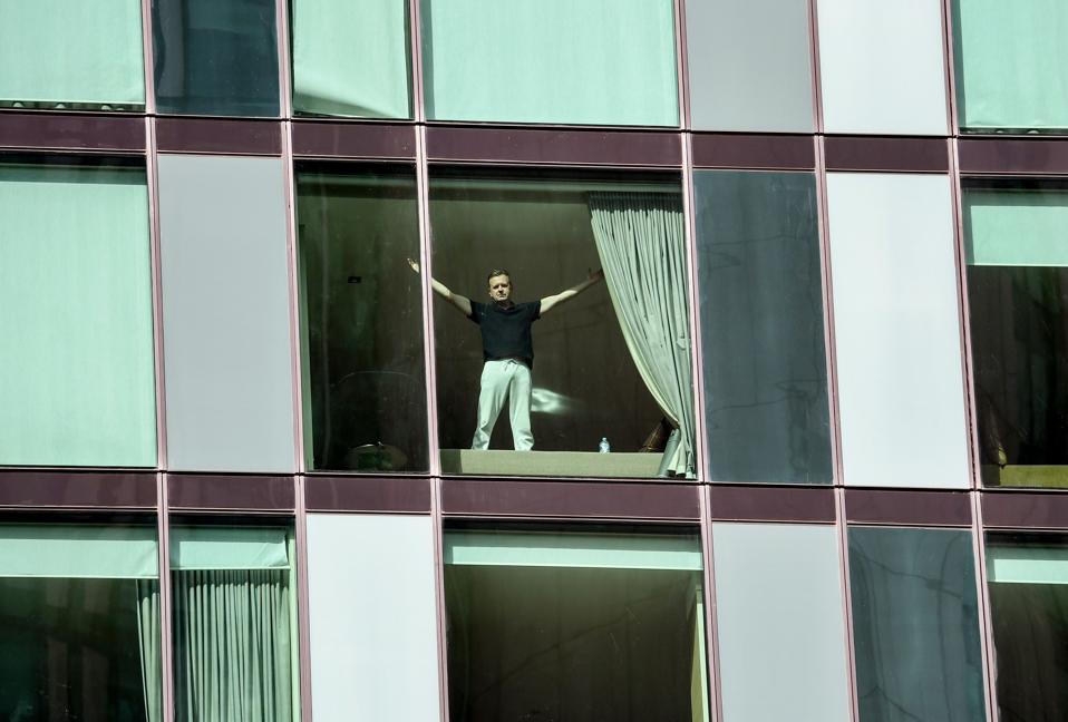 Man gestures from window of covid-19 quarantine hotel in Australia