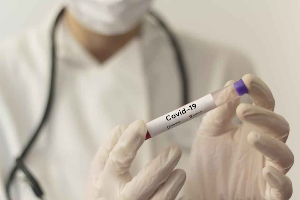 Midsection Of Doctor Holding Test Tube In Laboratory