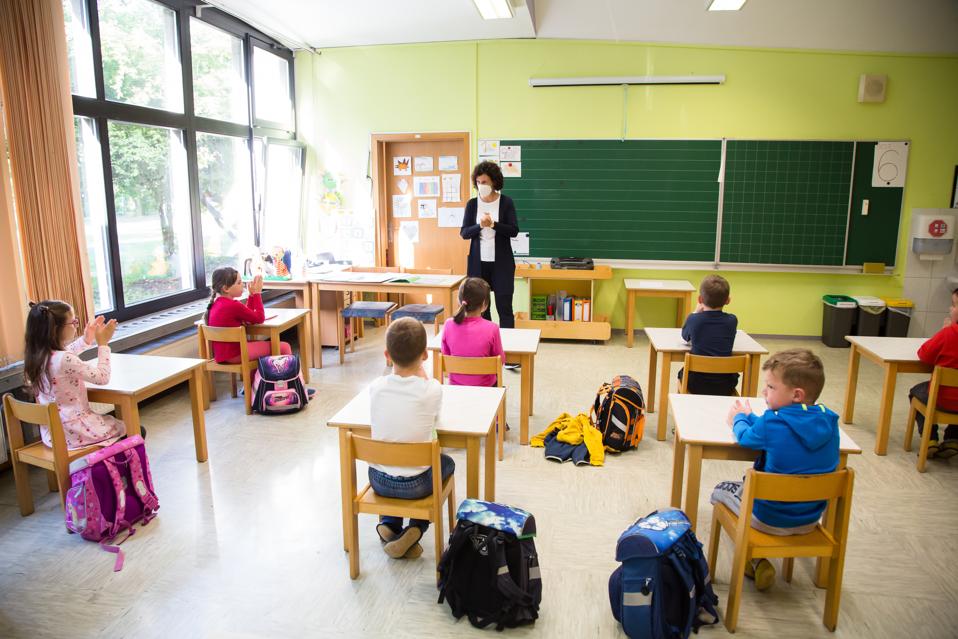 A primary school teacher wearing a face mask as preventive...
