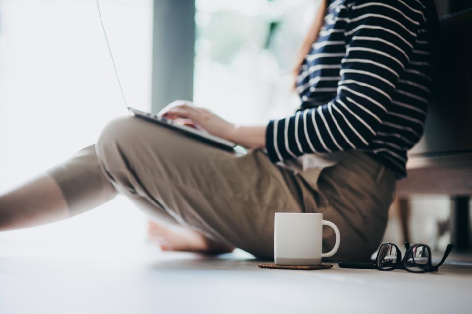Cropped shot of a young Asian woman in self isolation using laptop while working from home