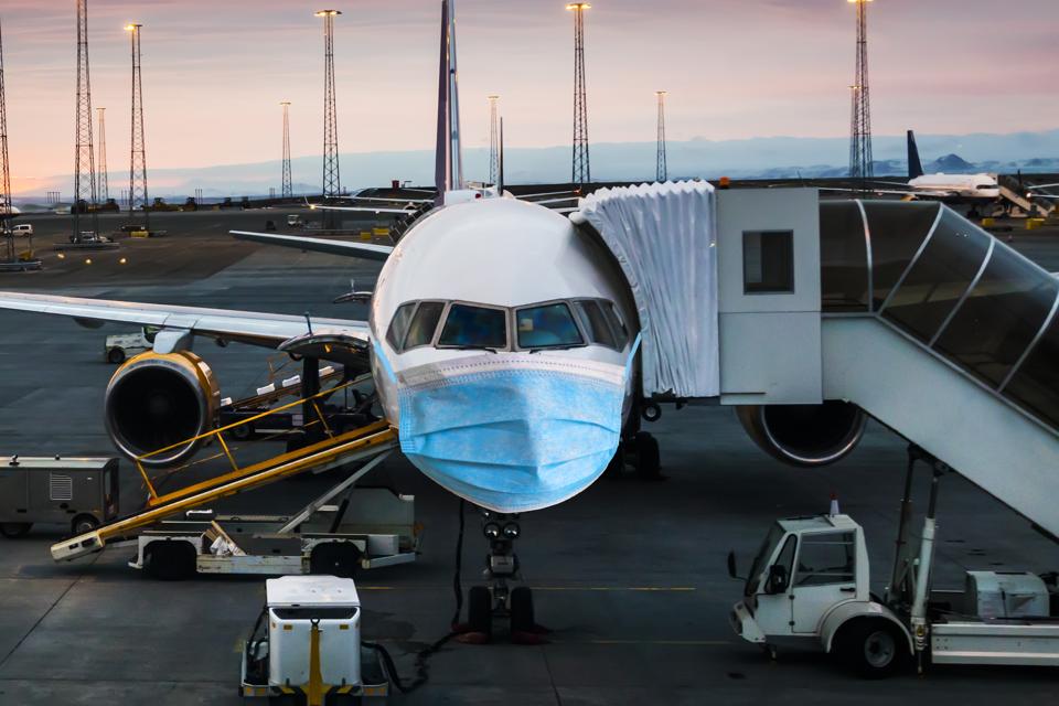 Airplane in a medical mask. Air Travel Crisis Concept