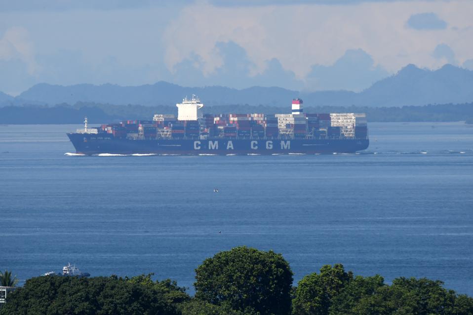 A container vessel leaves the port of Singapore.