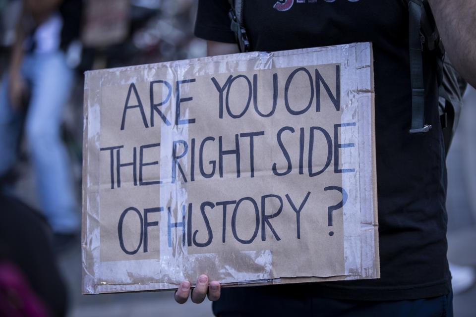 A protester in Manhattan has a homemade sign that says, ″Are You On The Right Side Of History?″ as part of the Warriors of the Garden Peaceful Protest on Donald Trump's 74th birthday.