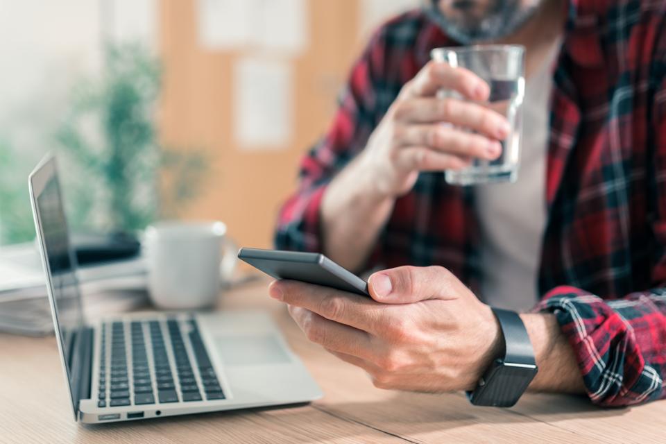 Gig worker drinking water and using mobile phone