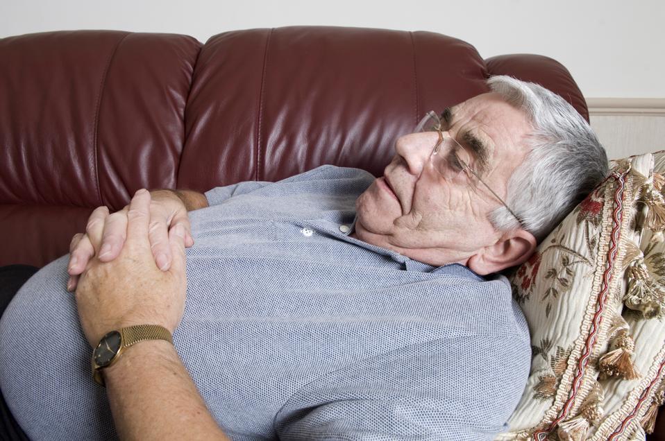 Senior man napping on sofa