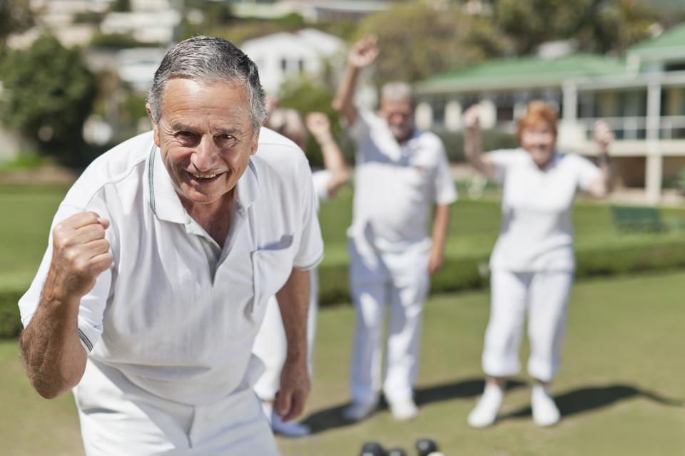 Older people playing lawn bowling