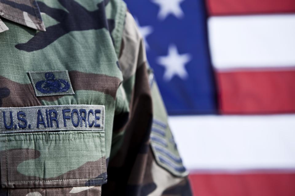 U.S. Air Force airman standing in front of U.S. flag