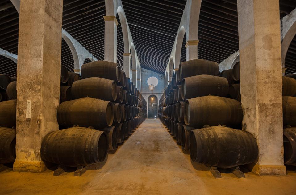 Barris de xerez em linha de passeio numa bodega em Jerez, Espanha